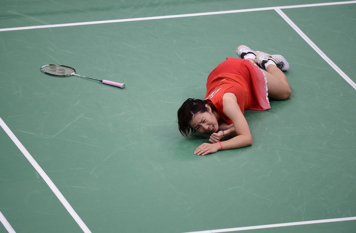 Sayaka Sato của Nhật Bản nằm đau đớn khi đang thi đấu ở vòng bảng đơn nữ môn cầu lông.